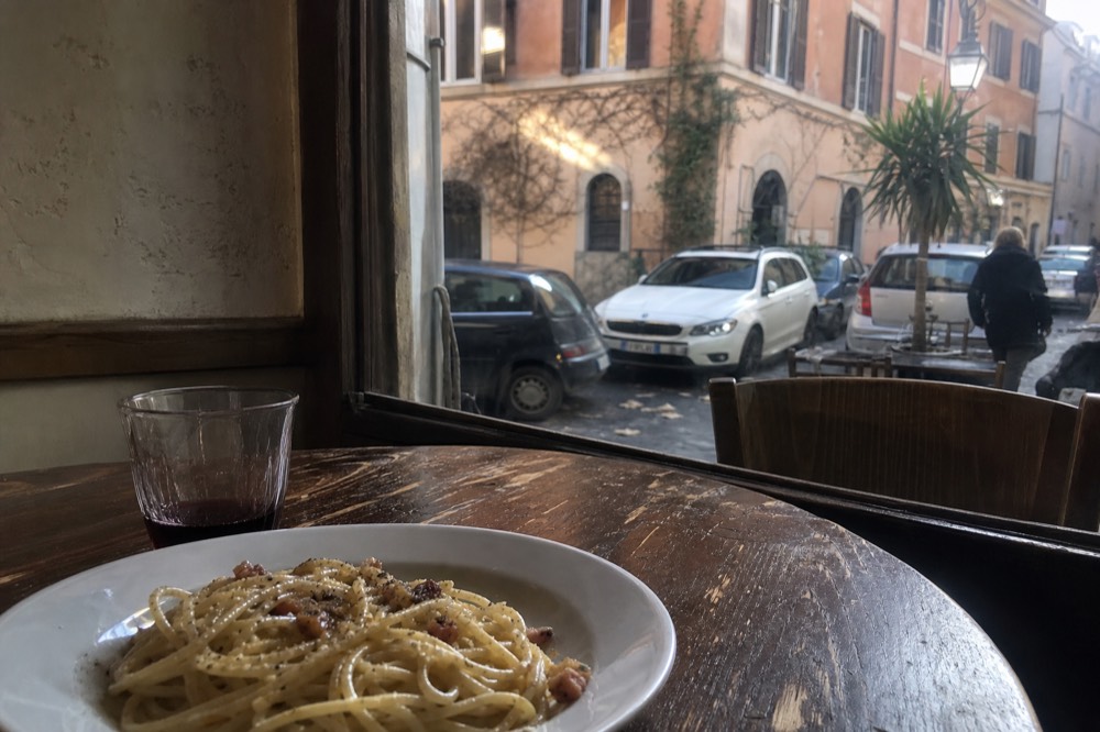 A rustic plate of spaghetti alla gricia with crisp guanciale pieces and black pepper