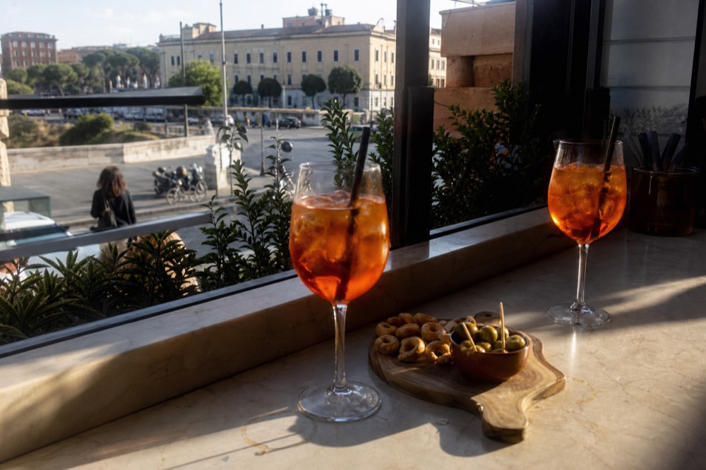 Spritz glasses and snack board on a marble bar table