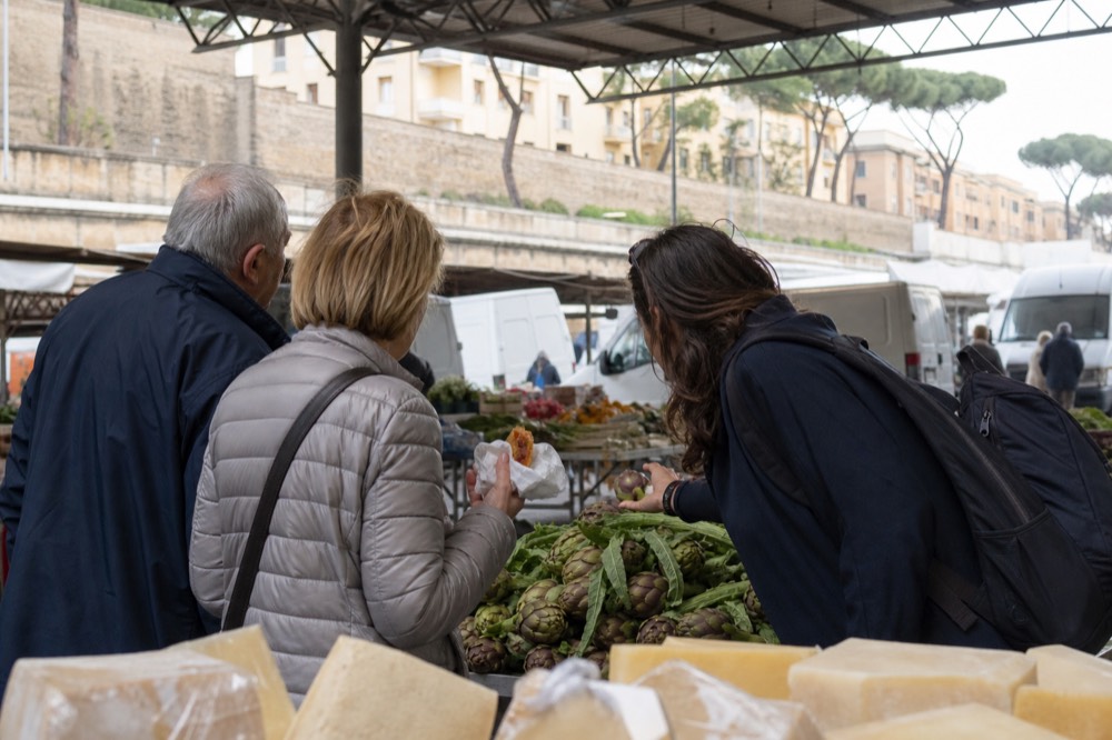 A guide speaking with a small group at a Roman market stall
