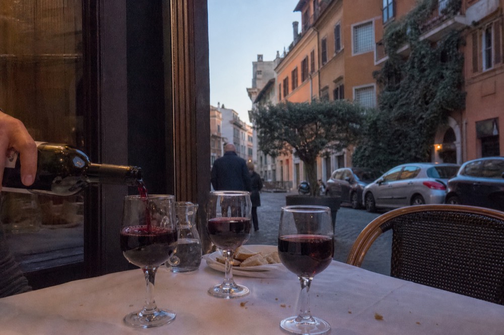 Red wine being poured into glasses on a restaurant table in Rome