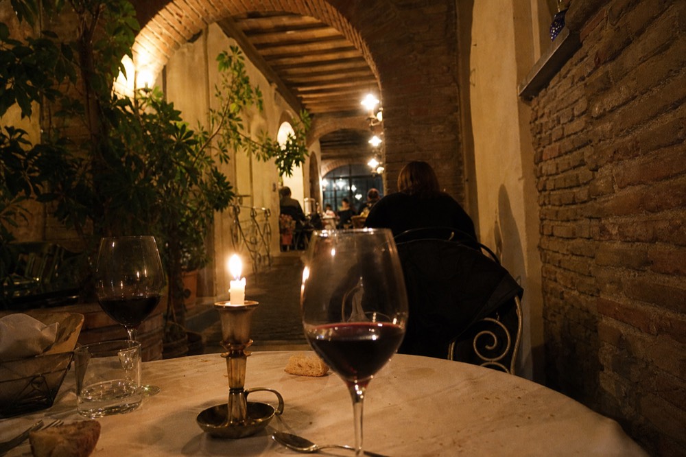 Set dinner table with wine glasses in a candlelit Trastevere trattoria, no text, no logos, no people