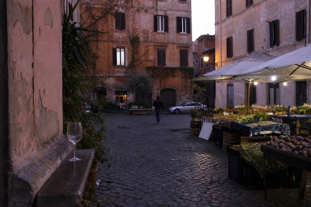 Trastevere square in autumn with market stalls and falling evening light, no text, no logos, no people
